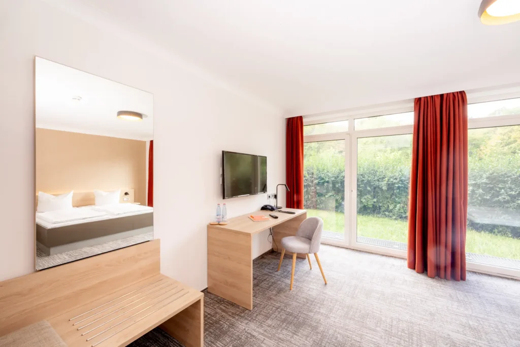 Arbeitsplatz und Fernseher in einem der Zimmer des K6.