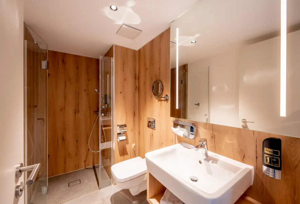 Bad in einem der Zimmer im K6. Zu sehen ist das Waschbecken, das WC und die Dusche.