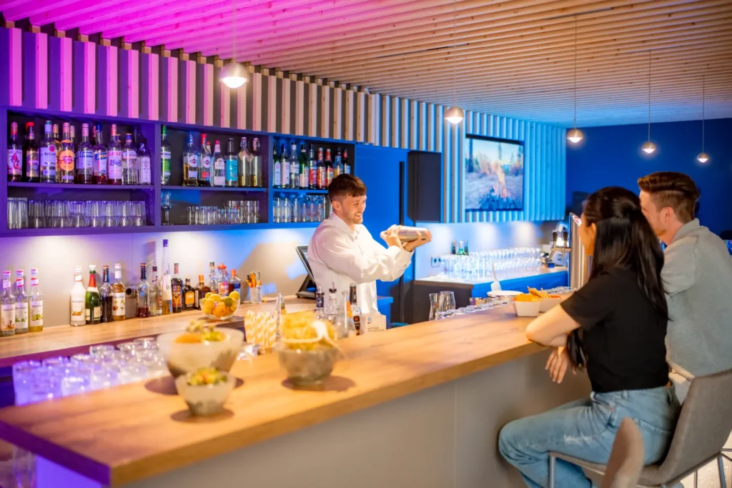 Bar in der Mixed Zone Hinter der Bar wird ein Cocktail von einem Mitarbeiter des K6 Seminarhotels zubereitet.