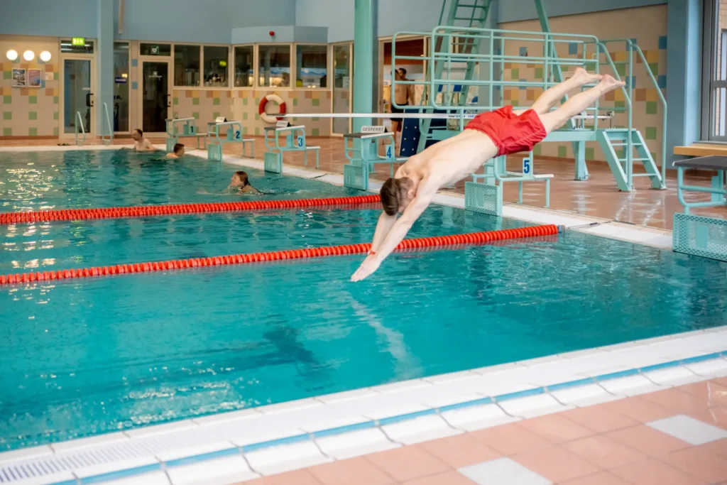 Schwimmbad FSZ Mann springt in ein Schwimmbecken